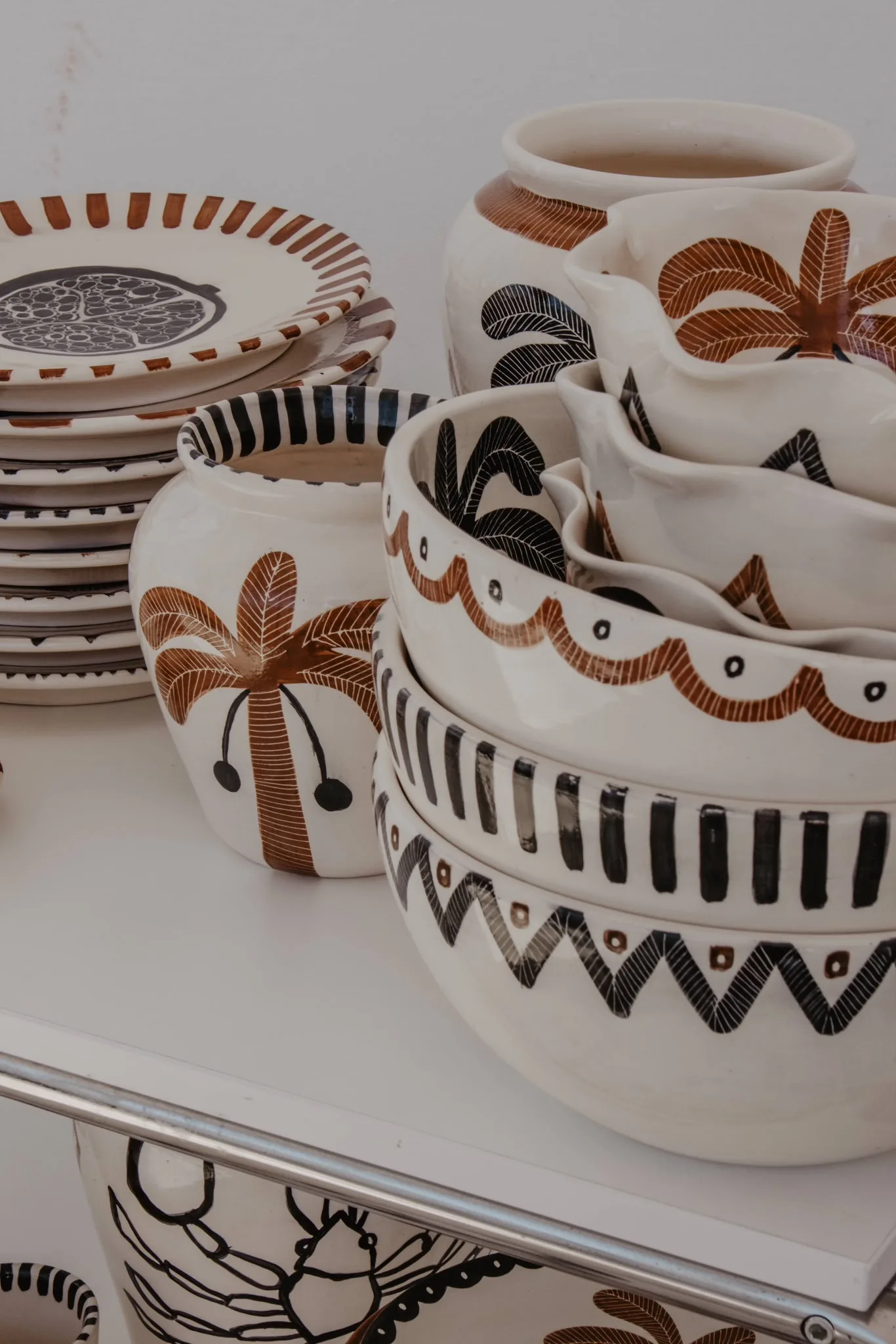 A stack of Anna Ciok hand-painted bowls and mugs