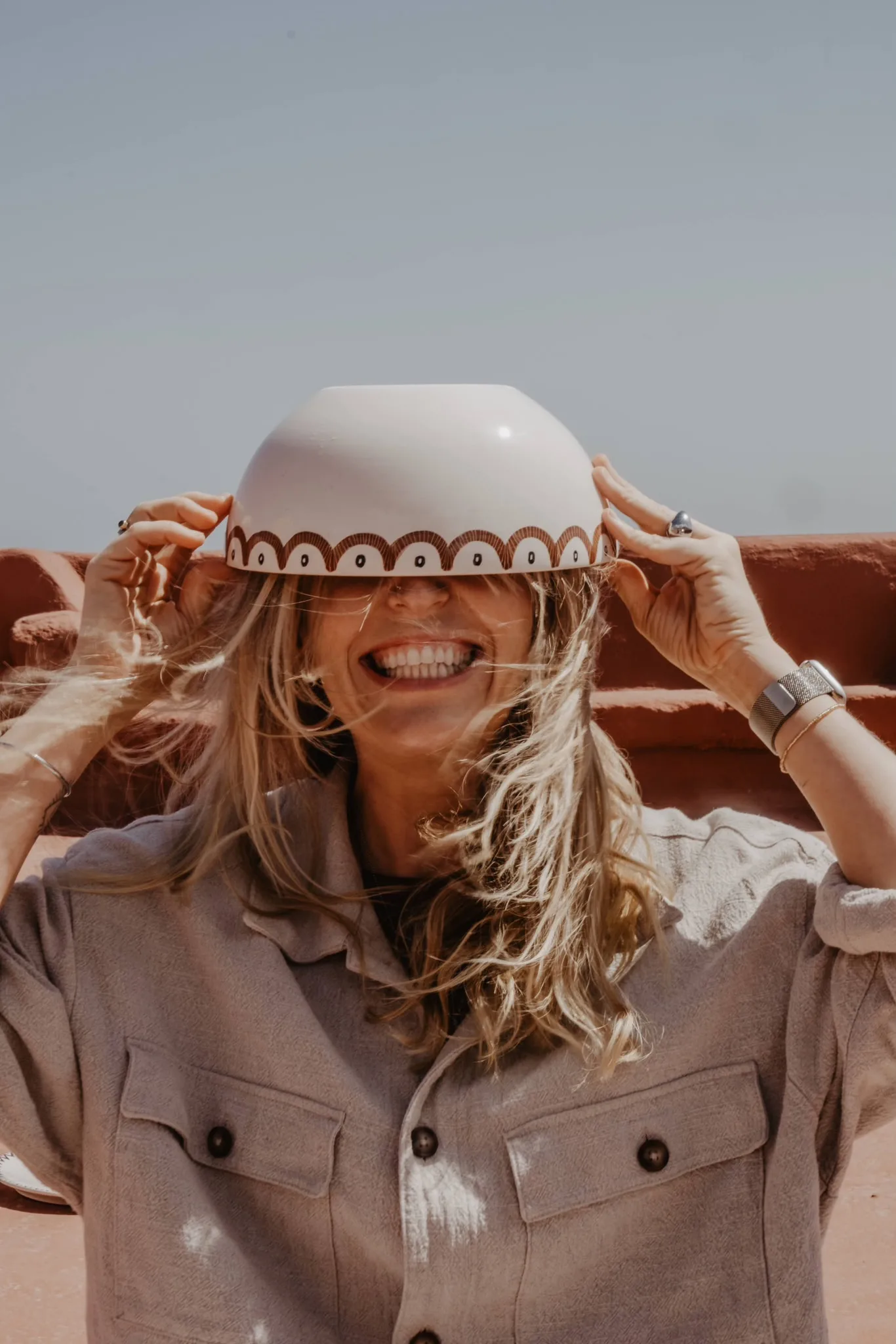 Anna Ciok holding a hand-painted bowl in front of her face
