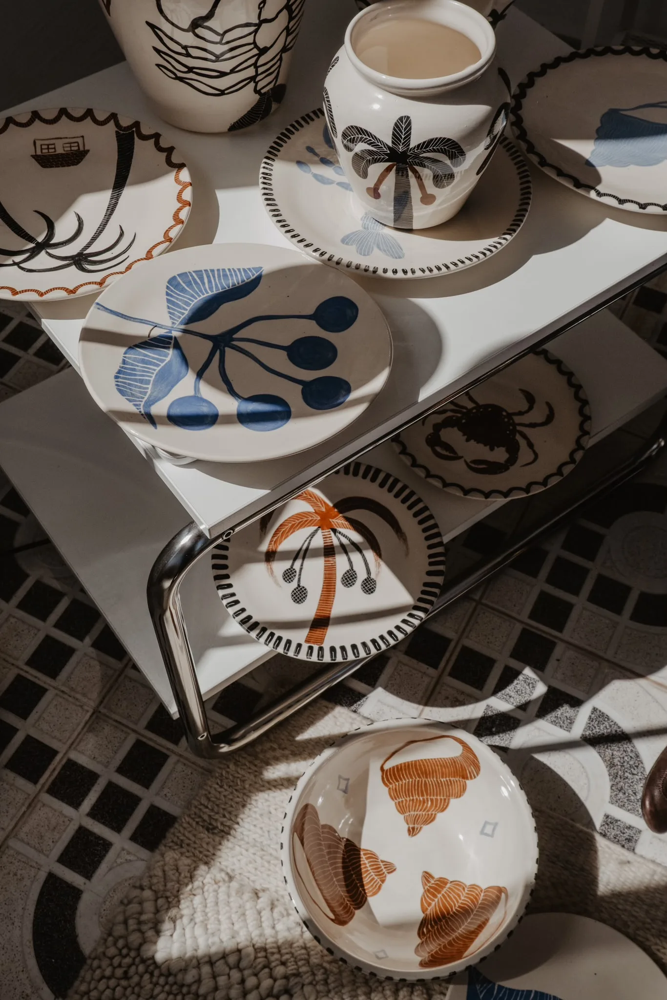 Anna Ciok hand-painted plates and mugs on a table