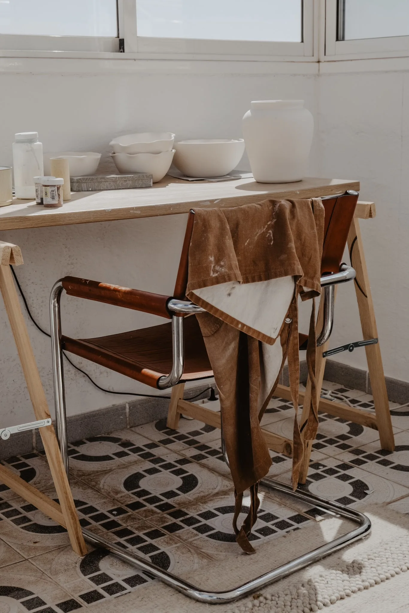 A chair and table in a bright ceramics studio