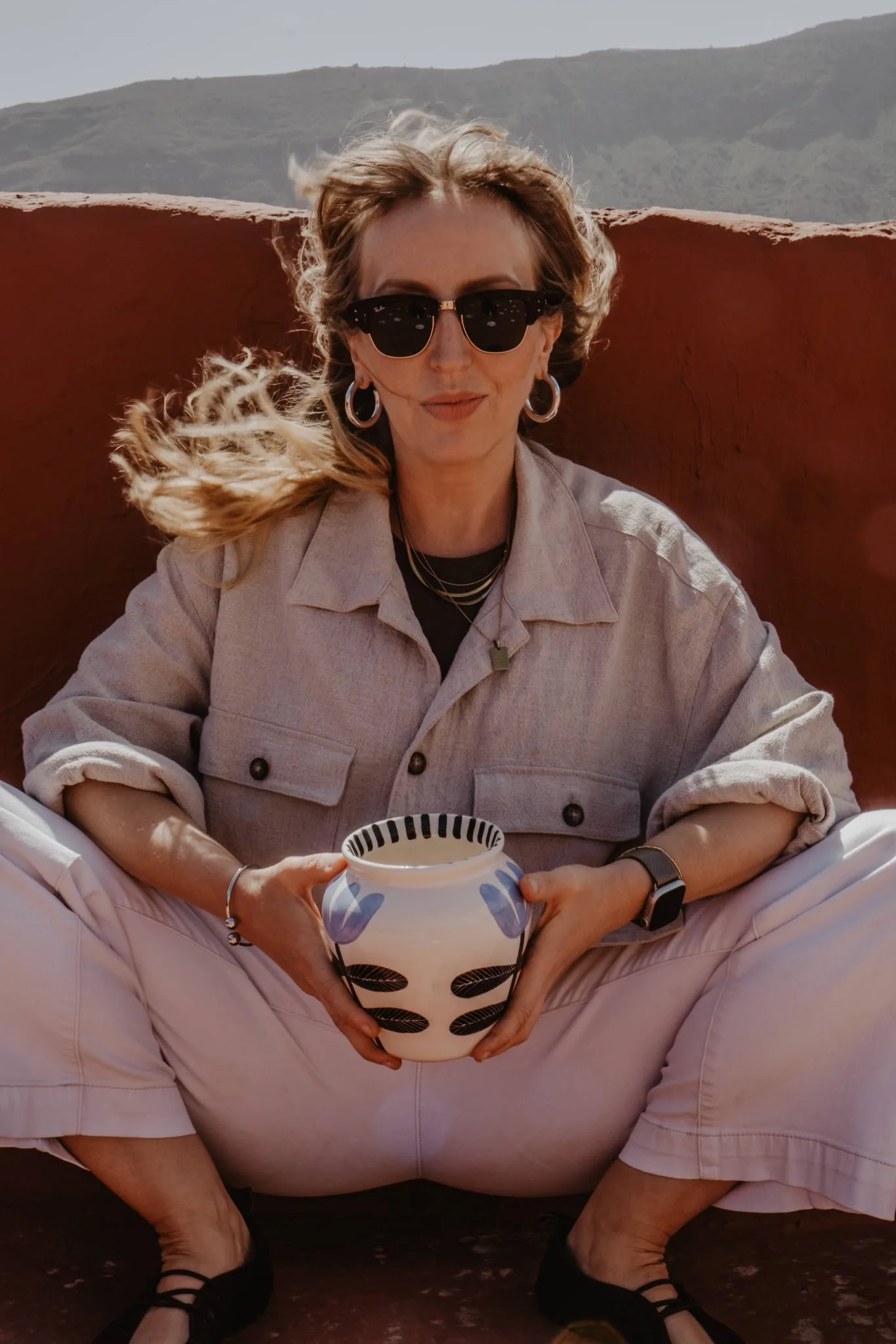 Anna Ciok seated on a terrace with a hand-painted bowl
