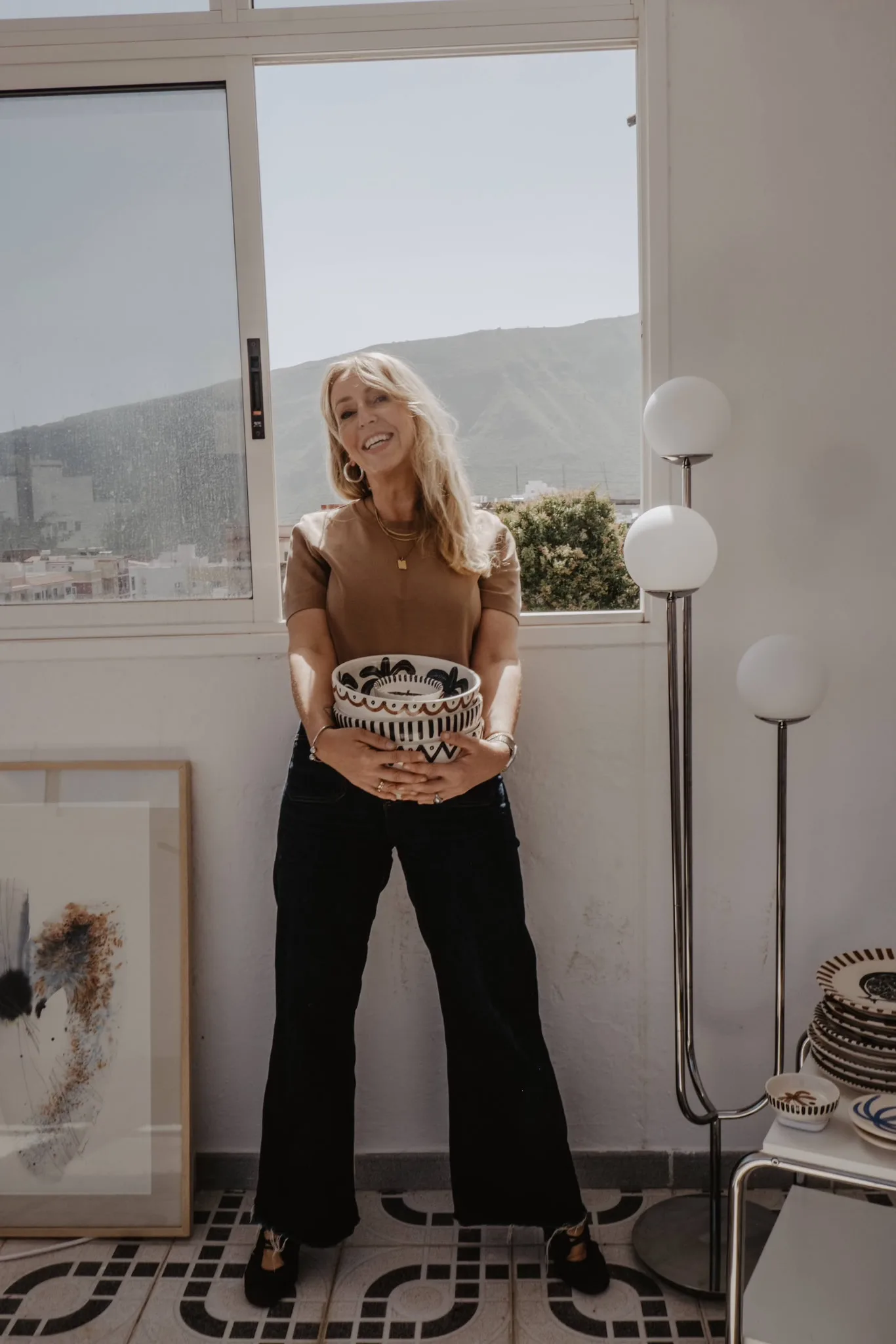 Anna Ciok standing in the studio with a hand-painted bowl